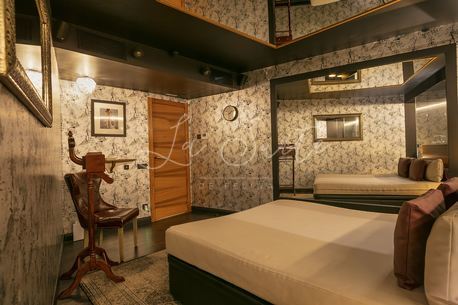 habitación Elegancia, paredes y suelo azulados, amoblado color marrón claro en La Suite, Barcelona